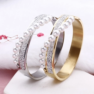 Crossed titanium steel bracelet with pearls and diamonds on white stone base