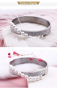Detail of silver titanium steel bangle with white pearls and sparkling rhinestones
