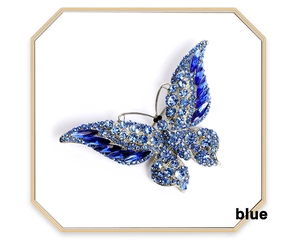 Close-up of elegant blue crystal butterfly brooch with sparkling silver metal base