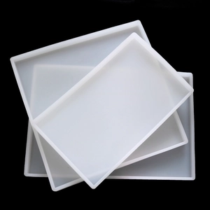 Three stacked large rectangular silicone molds for resin casting on black background