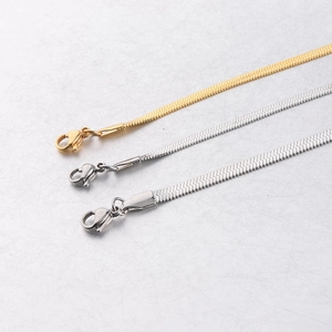 Detailed close-up of gold and silver flat snake bone chains with lobster clasps