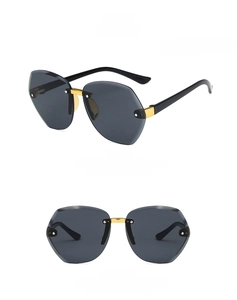 Detail of rimless hexagonal kids sunglasses with grey lenses and gold metal joints