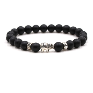 Close-up of matte black beads bracelet featuring a vintage silver elephant charm