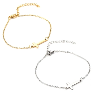 Détail de bracelets pendentif croix en or et argent avec chaîne à maillons réglable