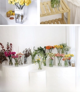 Close-up of various sizes of transparent acrylic flower buckets on a wooden shelf
