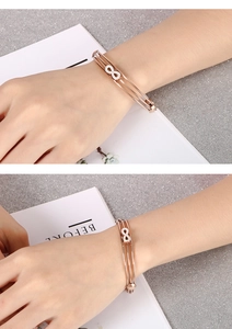 Détail d'un bracelet infini en or rose avec cristaux porté sur le poignet d'une femme