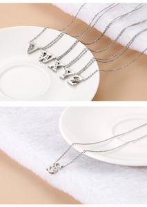 Close-up of silver pendant necklaces with sparkling rhinestones in letter shapes V W X Y Z S