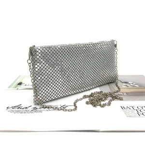 Close-up of silver sequin envelope clutch bag with sleek metal mesh and chain strap