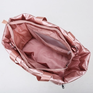 Metallic pink gym tote bag with waterproof nylon surface and interior storage compartments