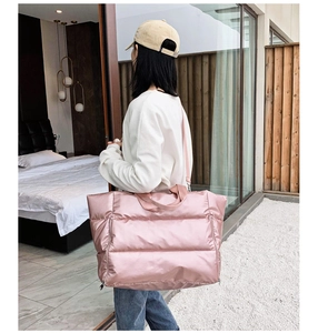 Detailed shot of a quilted pink gym bag worn by a model in a modern room setting