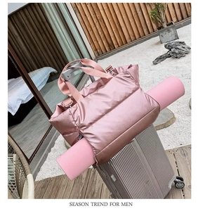 Pink waterproof fitness bag shown on a silver suitcase with a dedicated yoga mat strap