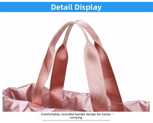 Detailed macro view of reinforced handles and waterproof satin pink fabric on the sports bag