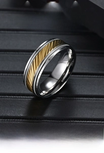 Macro shot of titanium steel ring with silver polished edge and golden textured inlay band