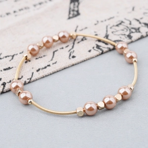 Golden spring wire bracelet with light pink pearls and metallic square beads in 45-degree view