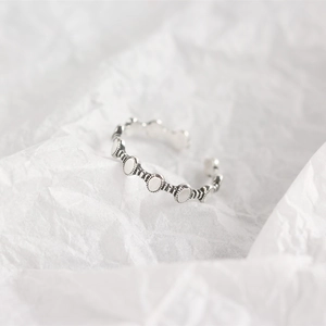 Dettaglio ravvicinato dell'anello a catena in argento sterling S925 su carta