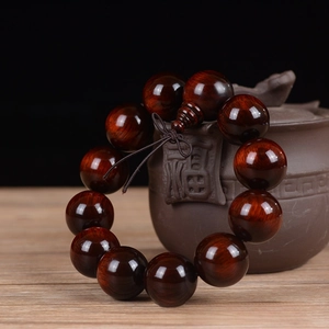 Detail of 20mm dark red sandalwood beads with clear grain hanging on a teapot