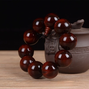 Detailed macro view of 25mm red sandalwood beads with natural wood grain and fine texture