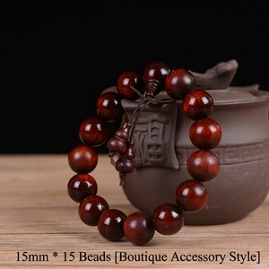 Detail view of 15mm red sandalwood prayer beads hanging on a clay teapot
