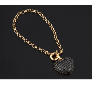 Detailansicht eines Goldketten-Armbands mit einem schwarz pavé-gefassten Herzanhänger