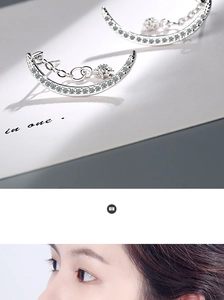 Macro shot of silver crescent moon earrings with tiny star pendant on a model