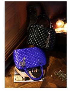 Macro shot of quilted shell bags in black and blue with metal chain charms