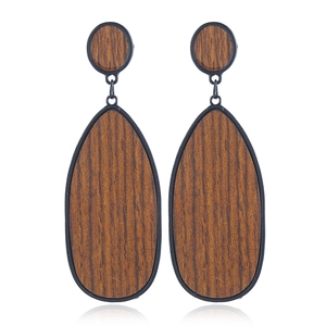 Détail de la texture grain de bois et du cadre noir sur boucles d'oreilles goutte