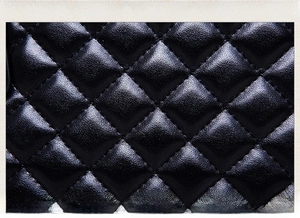 Macro detail of high-quality black quilted leather texture and neat stitching on handbags