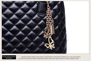 Detailed close-up of quilted black leather texture and gold butterfly hardware charm