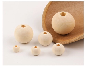 Detail view of various sizes of natural wooden beads with a decorative wooden spoon