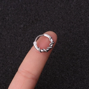 Vintage silver twisted hoop earring in stainless steel displayed on finger for size