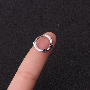 Macro shot of silver septal ring with twisted texture and crystal inlay on finger