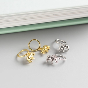Detailed view of 3D rhino charm hoop earrings in polished gold and silver finishes