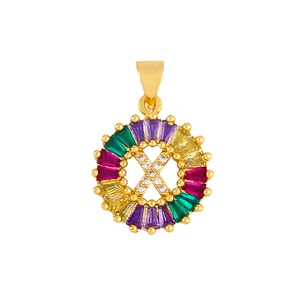 Detailed macro view of gold-plated pendant with letter X and colorful zircon stones