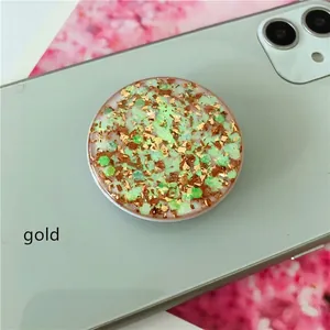 Detail of green epoxy phone grip featuring golden foil and hex glitter on a matching smartphone