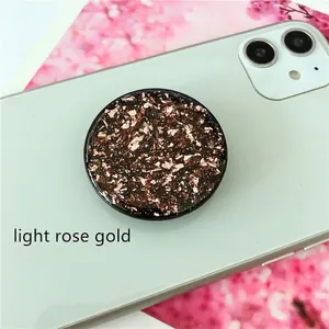 Close-up of light rose gold phone grip with glitter resin and metallic foil flakes