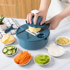 Action shot of dark blue vegetable slicer kit grating potatoes on a kitchen counter