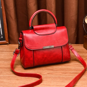 Vintage red leather handbag with metal round handle and adjustable shoulder strap