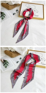 Detail of red and grey floral silk scarf tied on a bag and laid flat for styling