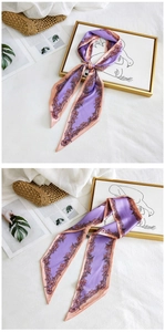 Macro detail of purple floral silk scarf tied as a bow with elegant pink edges