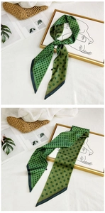 Detail of green polka dot silk scarf tied on a woven bag in a lifestyle setting