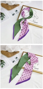 Detailed view of dual-sided green and pink silk scarf with horse print on straw bag