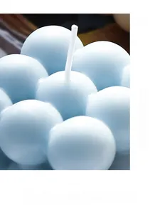 Detail van een lichtblauwe kubus bubbelkaars op een donkerbruin houten blad