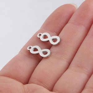 Polished silver stainless steel infinity symbol charms for DIY jewelry held in palm