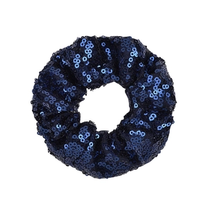 Detailed macro view of dark blue sequined scrunchie with sparkling fish scale texture