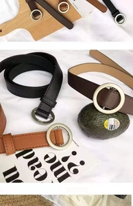 Macro shot of minimalist PU leather belts with round metal buckles in various vintage colors