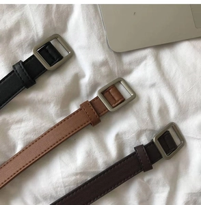 Detail of slim PU leather belts in black, camel and brown with matte square buckles