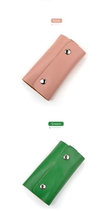 Dettaglio di portachiavi in pelle rosa e verde con doppia chiusura a scatto argento