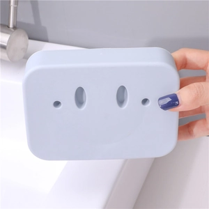 Light blue double-layer smiley face soap dish held in hand near a bathroom sink