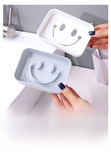 Detail of blue and white smiley face soap boxes with drainage holes for bathroom use