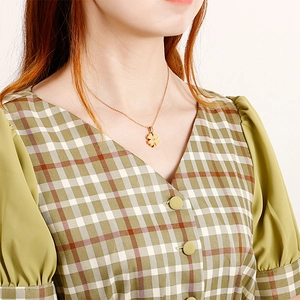 Elegant gold clover pendant necklace with zircon center on model's collarbone